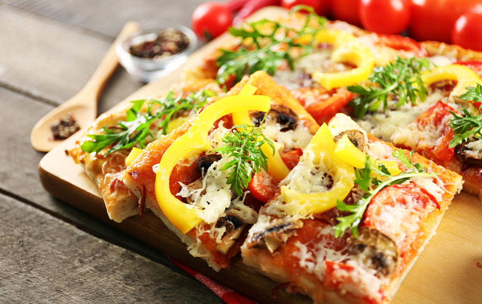 Pizzas découpée en carrés sur planche en bois